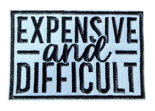 Expensive and Difficult embroidered patch with white script lettering on dark background