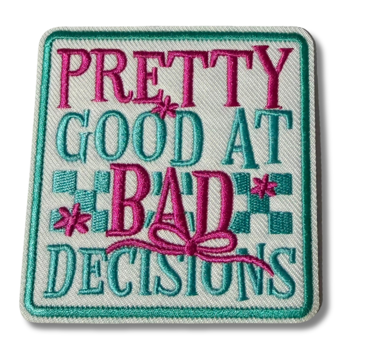 Embroidered patch with "Pretty Good at Bad Decisions" text by High Desert Hats, featuring colorful thread design on fabric background.