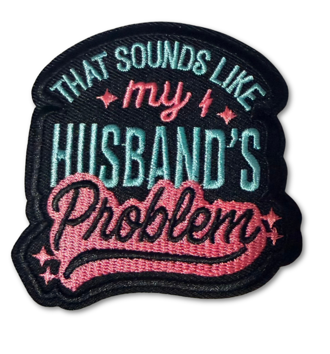 Embroidered patch reading "Sounds Like My Husband's Problem" from High Desert Hats, featuring detailed stitching and fabric texture.