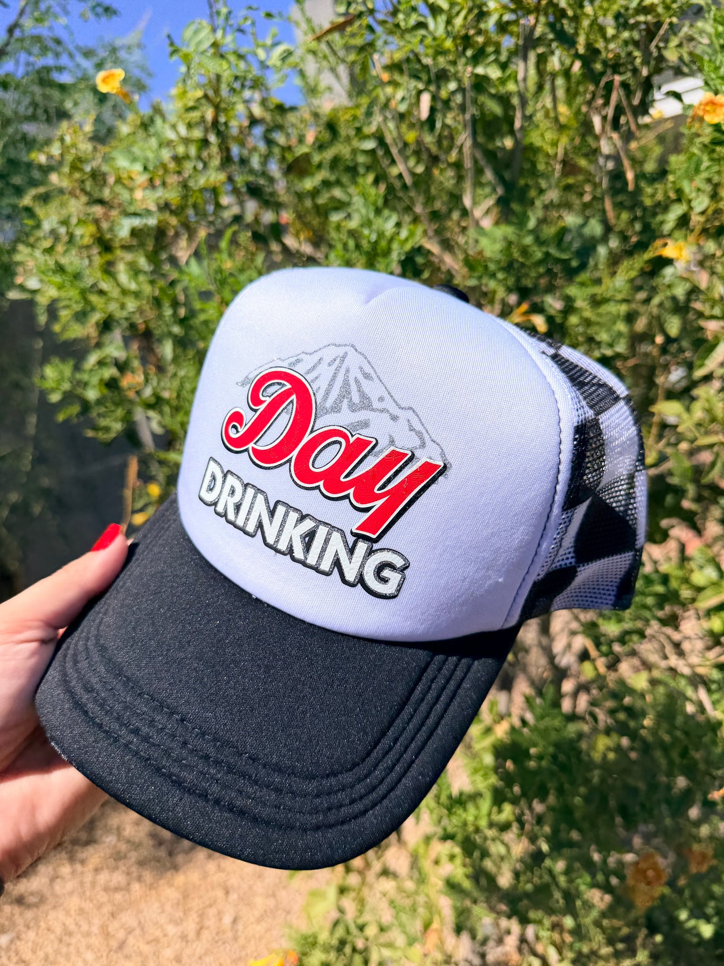 Day Drinking premade trucker hat by High Desert Hats featuring a casual design with a mesh back and adjustable strap.