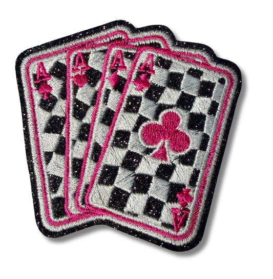 Pink checkered Aces embroidered patch by High Desert Hats featuring detailed stitched design on fabric background.