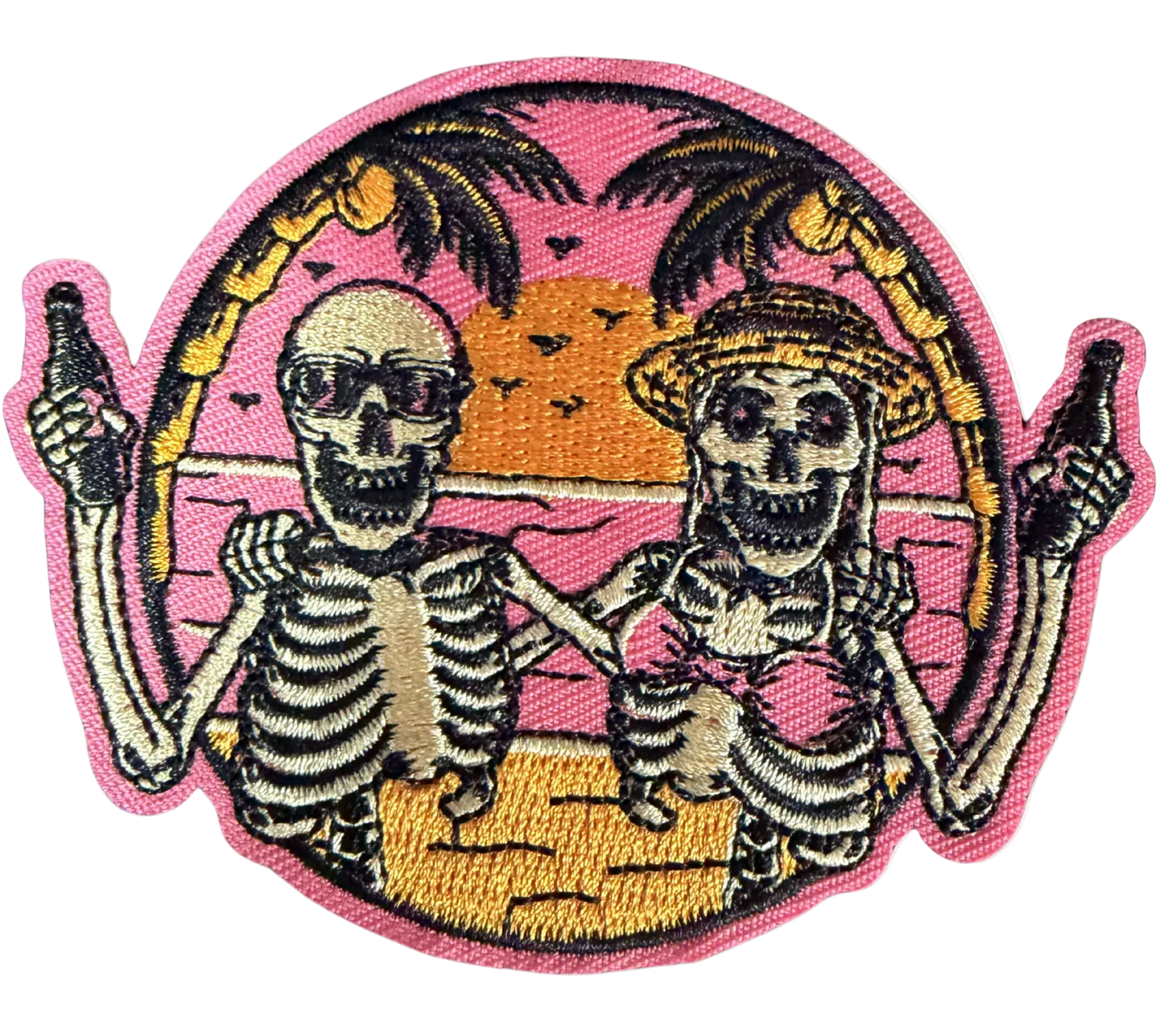 Two skeletons toasting bottles on a pink sunset beach with palm trees patch